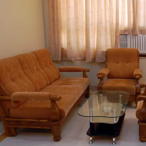 Seating area with brown cushioned sofa and armchairs with glass coffee table