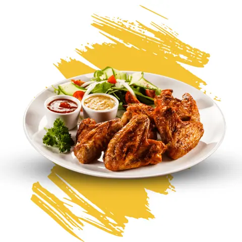 Plate of grilled chicken wings with two dipping sauces and salad garnish