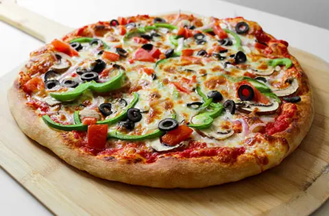 Vegetable pizza with olives, green peppers, tomatoes, and cheese on wooden board