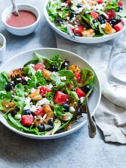 Fresh salad with mixed greens, grilled chicken, blueberries, and feta cheese