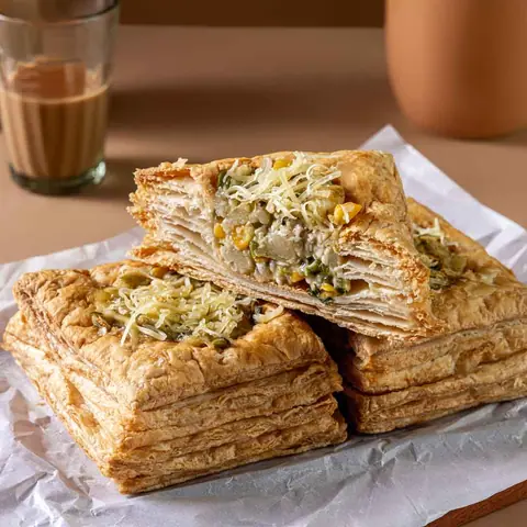 Layered vegetable puff pastry with grated cheese on top