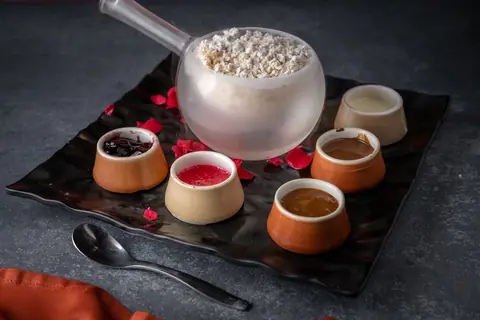 Traditional Indian dessert served in clay pots with a bowl of rice pudding