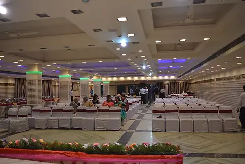 Spacious dining hall with rows of covered chairs and tables
