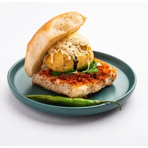 Vada pav with green chili on a blue plate