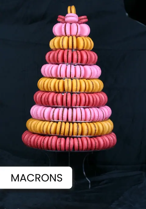 Tower of pink, red, and yellow macarons stacked in a cone shape
