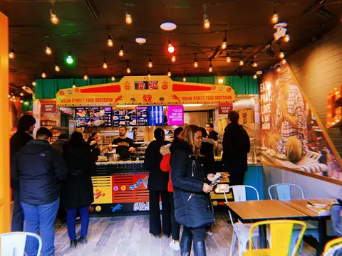 Customers ordering food inside Chaska Food Point with colorful decor