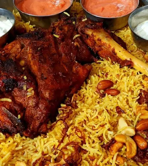 Spiced grilled meat served on biryani rice with nuts and side sauces