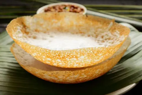 Crispy dosa served on a plate with a bowl of chutney