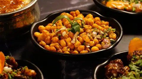 Spiced roasted chickpeas served in a black bowl with garnishing