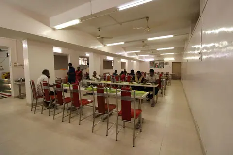 Spacious dining area with metal chairs and tables in Geetha Cafe