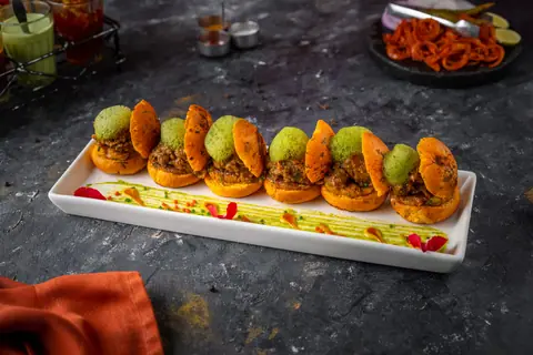 Assorted Indian street food snacks arranged on a rectangular white plate