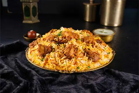 Plate of chicken biryani with spices and garnishing