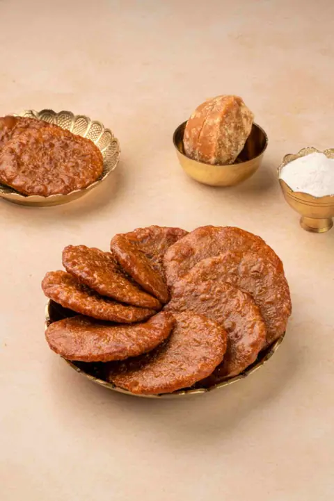 Variety of Indian sweet and savory snacks on brass plates
