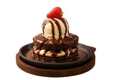 Chocolate brownie topped with vanilla ice cream, chocolate sauce, and a strawberry