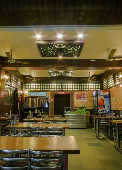Interior view of Zam Zam Fast Food restaurant with tables and ceiling fans