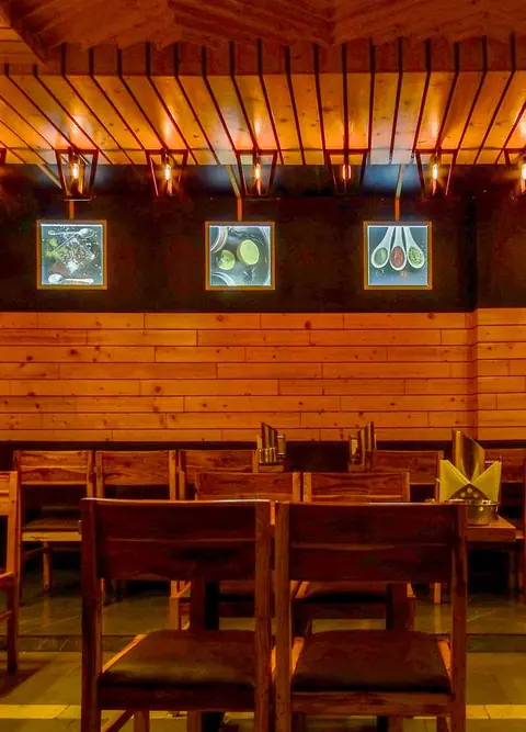 Wooden seating area with warm lighting inside Zam Zam Fast Food