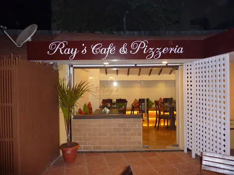 Entrance of Ray's Cafe and Pizzeria with outdoor seating and signage