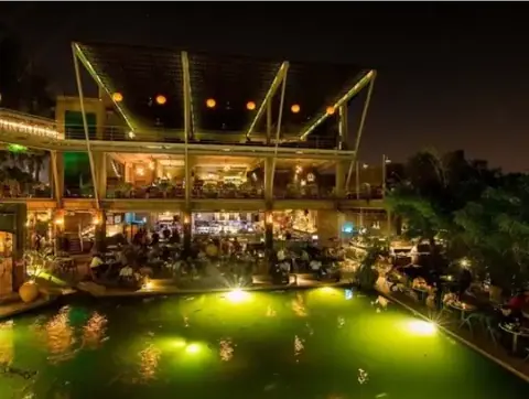 Night view of Byg Brewsky with illuminated pool and outdoor seating