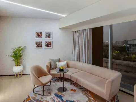 Modern seating area with beige sofa and armchair near large window