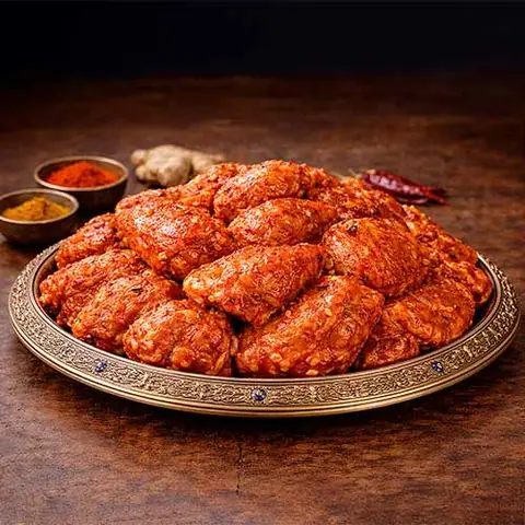 Plate of marinated chicken pieces with spices on a decorative tray