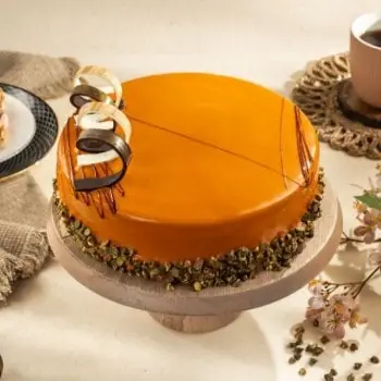 Round caramel-glazed cake with chocolate decorations on a cake stand