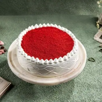 Round white cake with red topping on a marble stand