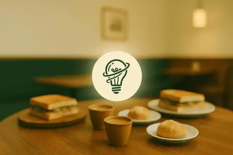 Two sandwiches, two cups of tea, and two bread rolls on plates