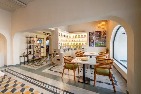 Bright cafe interior with wooden chairs and decorative shelves