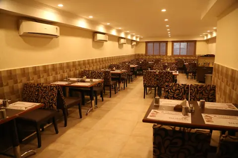 Spacious dining area with tables and chairs in Daalchini Restaurant