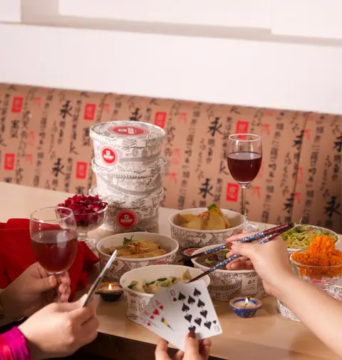 Chinese and Thai dishes with wine glasses on a table at Berco's
