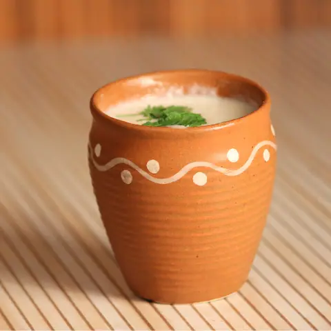 Buttermilk served in a traditional clay cup with coriander garnish