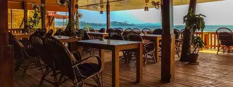 Wooden deck seating area with tables and chairs overlooking water