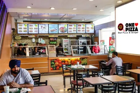 Interior view of One Love Pizza Fast Food Franchise with seating and counter