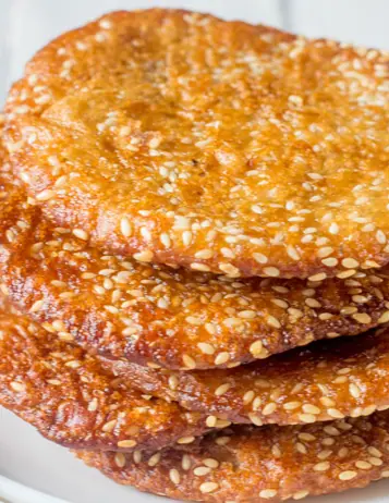 Stack of sesame seed-coated Indian sweet biscuits