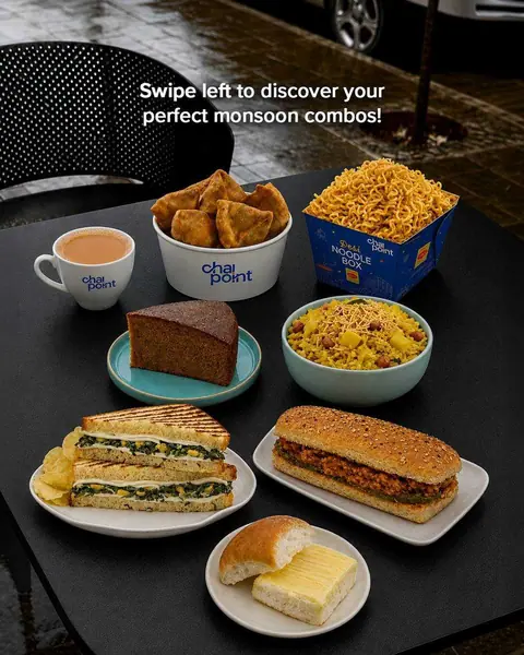 Tea, samosas, noodles, poha, cake, sandwiches, and buttered bun on table