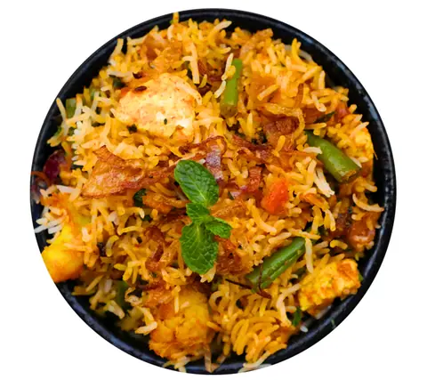 Bowl of vegetable biryani garnished with fried onions and mint leaves