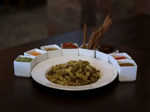 Indian spiced pasta with assorted spices in small white containers