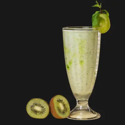 Kiwi smoothie in a tall glass with fresh kiwi slices and mint garnish