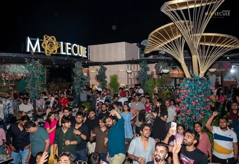 Crowded outdoor night view of Molecule Gwalior with illuminated signboard