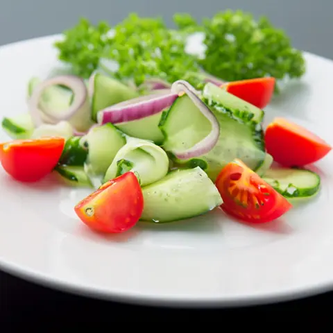 Fresh cucumber, tomato, and onion salad with lettuce garnish