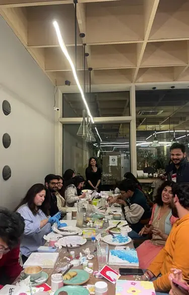 Group of people sitting around a long table inside the cafe