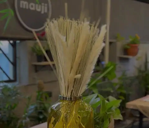 Decorative dried wheat stalks in a glass vase inside the cafe