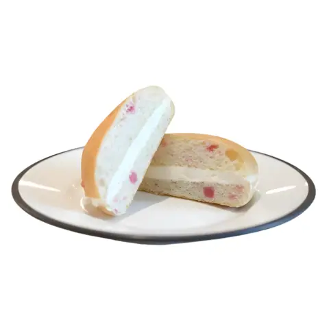 Cream-filled bun with fruit pieces on a white plate