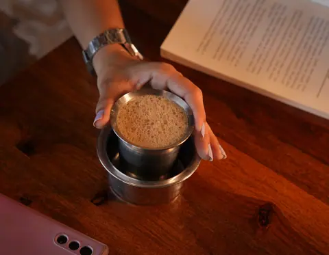 Traditional South Indian filter coffee in a stainless steel tumbler and davara