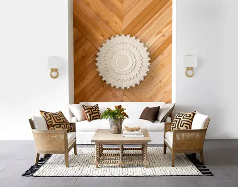 Cozy seating area with white sofa, wooden chairs, and decorative wall art