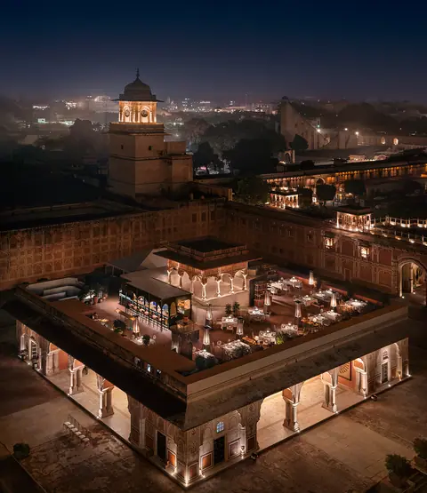 Night view of The Sarvato Jaipur rooftop dining area with city lights
