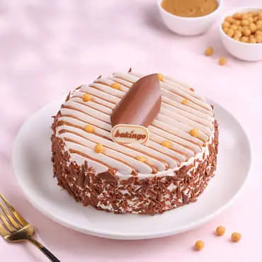 Chocolate and vanilla layered cake with chocolate shavings and Bakingo topper