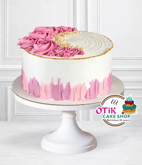 Round cake with pink rose frosting and white cream on a cake stand