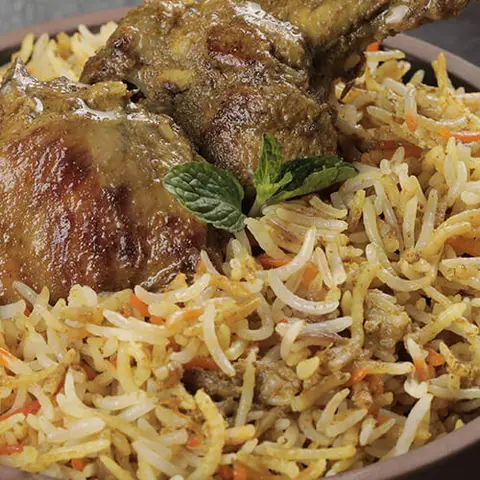 Plate of chicken biryani garnished with mint leaves