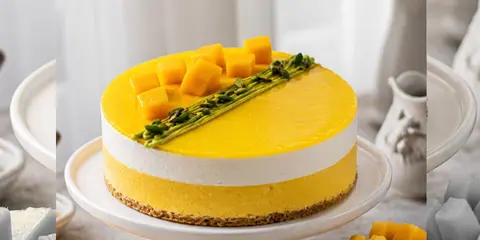 Mango mousse cake topped with fresh mango cubes and pistachios